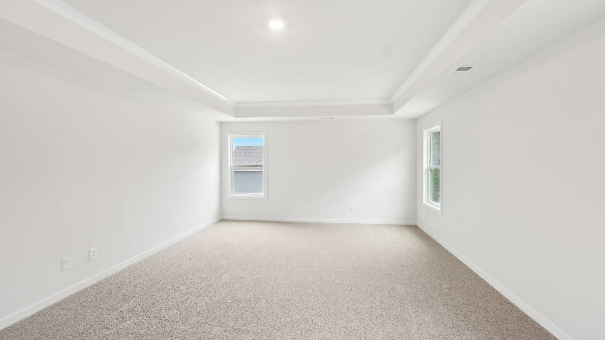 Carpeted bedroom with windows
