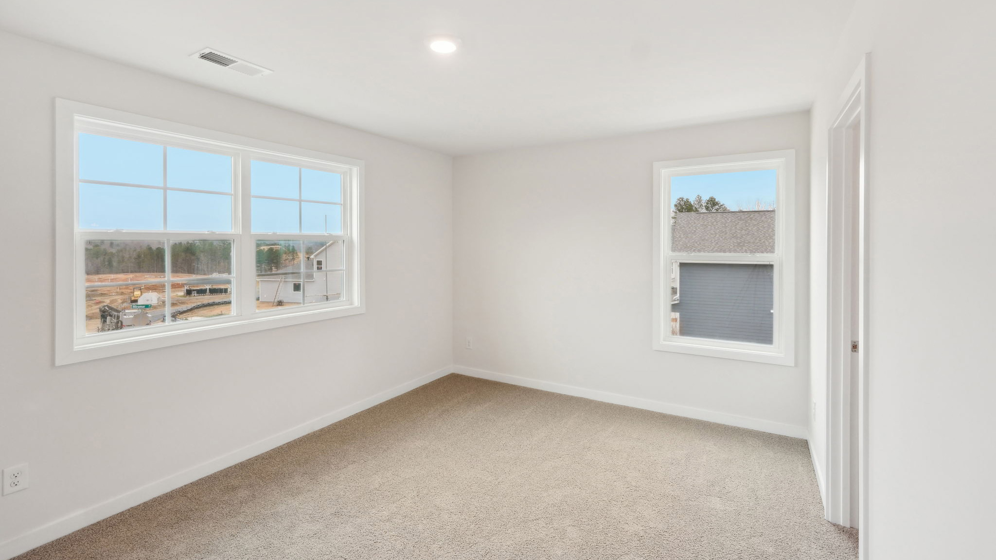 Carpeted bedroom with windows