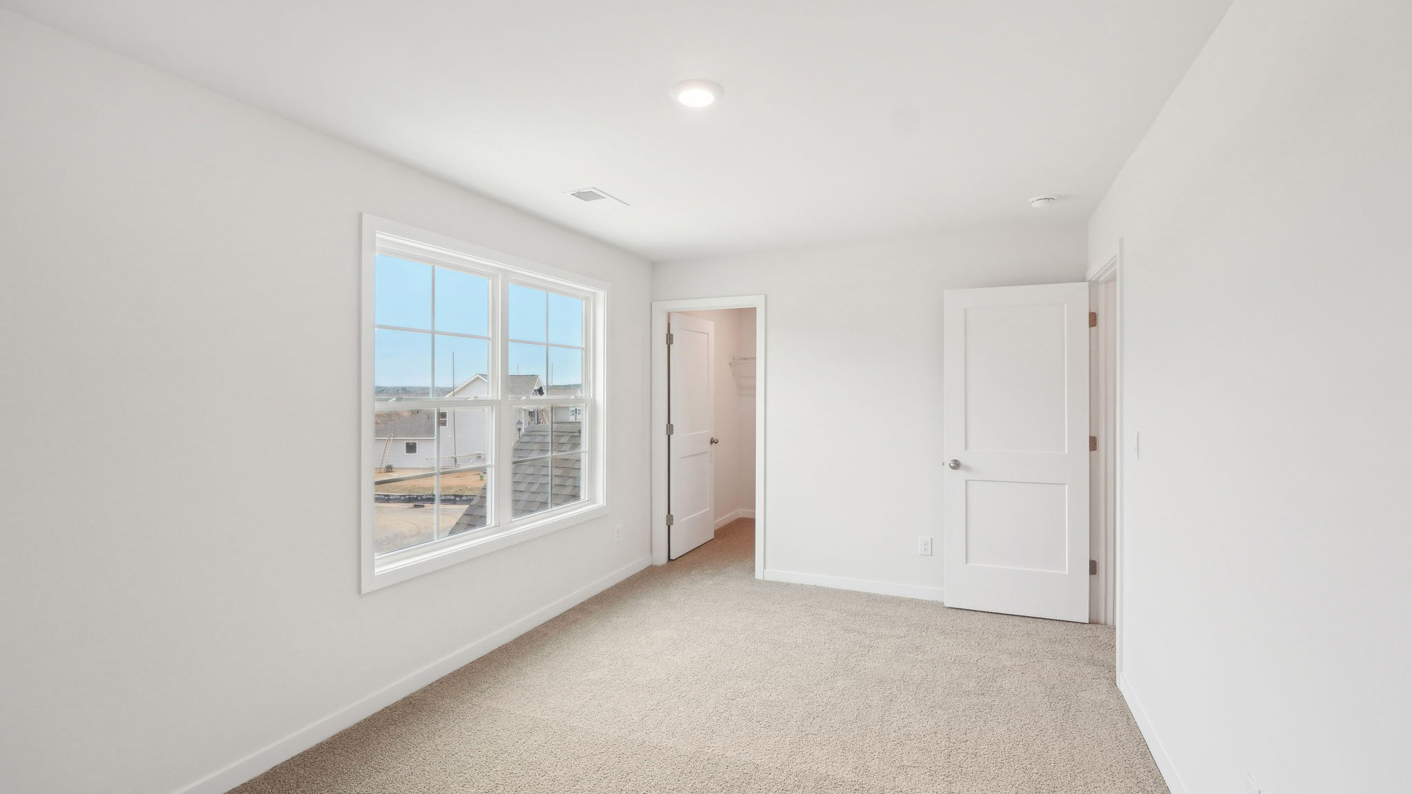 carpeted bedroom with large window