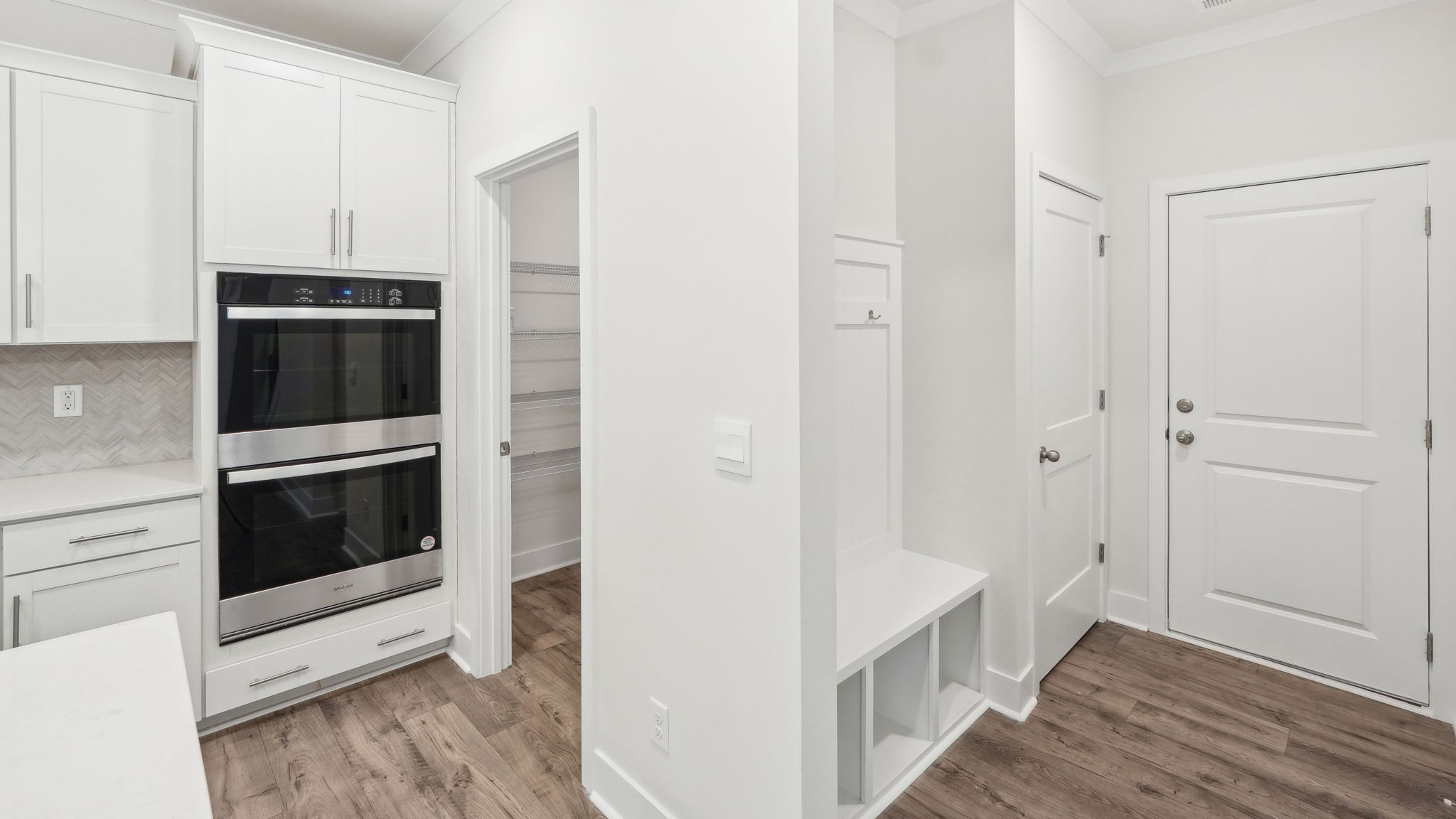 Kitchen and island with white cabinets and stainless steel appliances