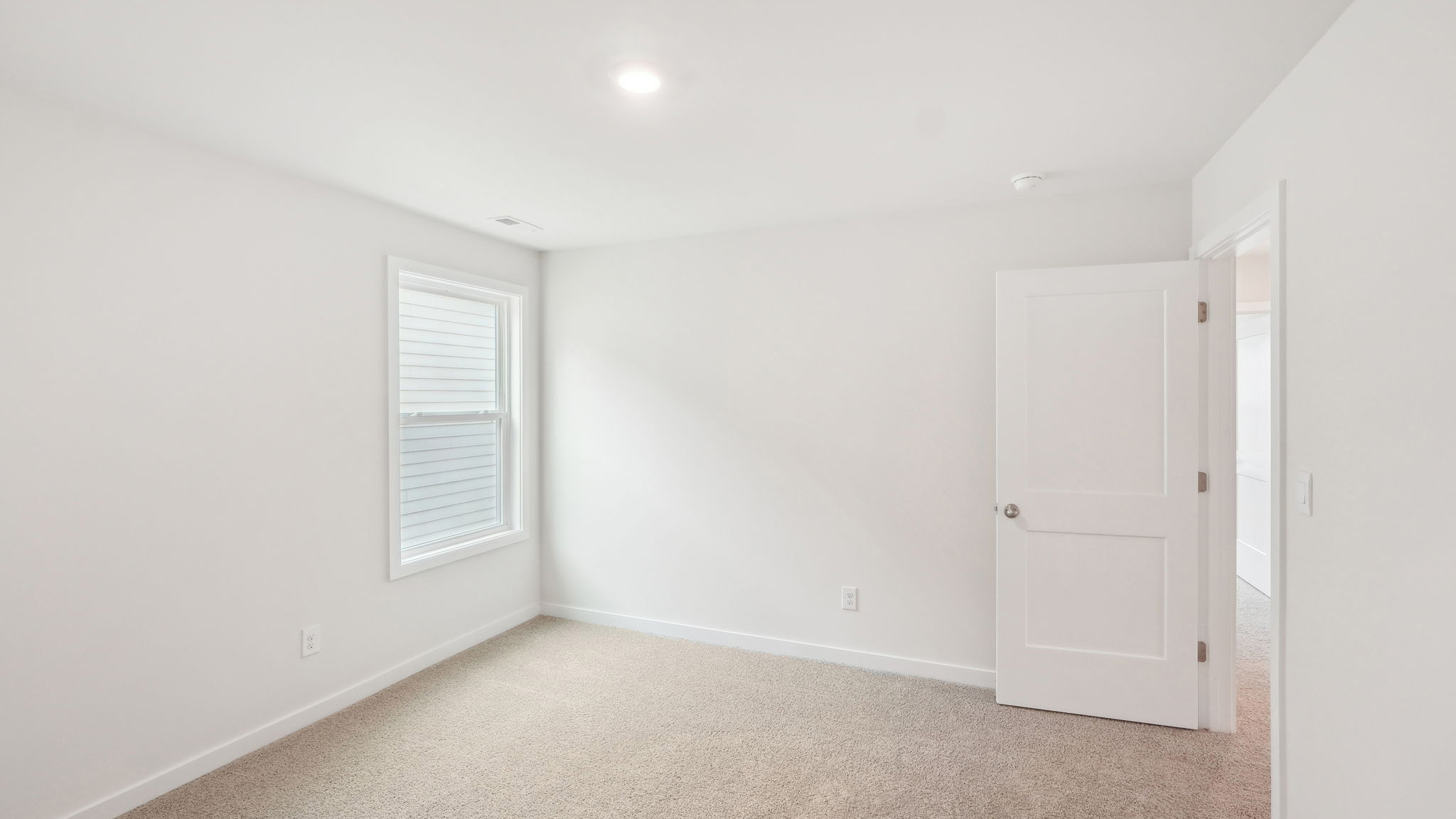 carpeted bedroom with large window