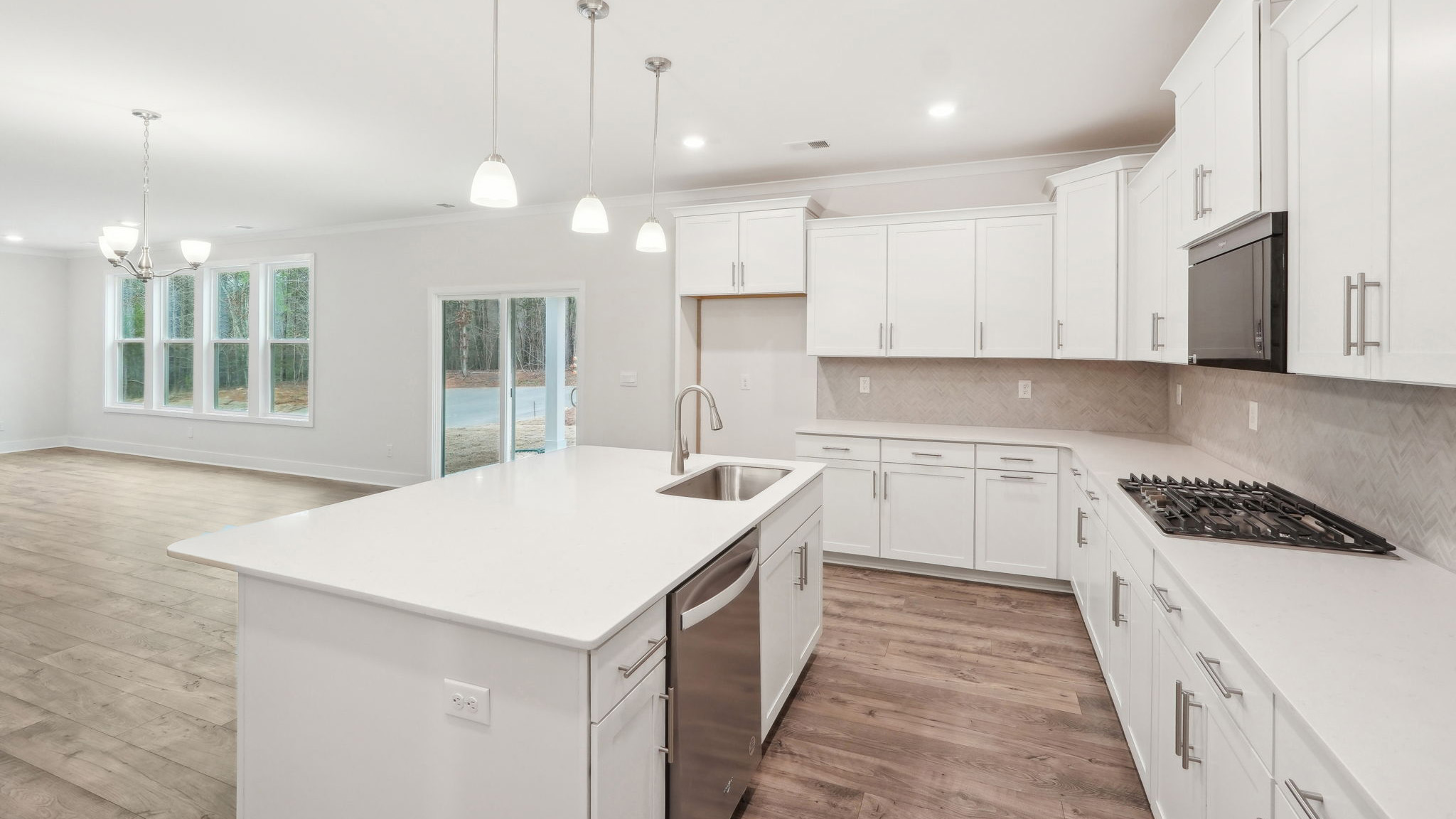 Kitchen and island with white cabinets and stainless steel appliances