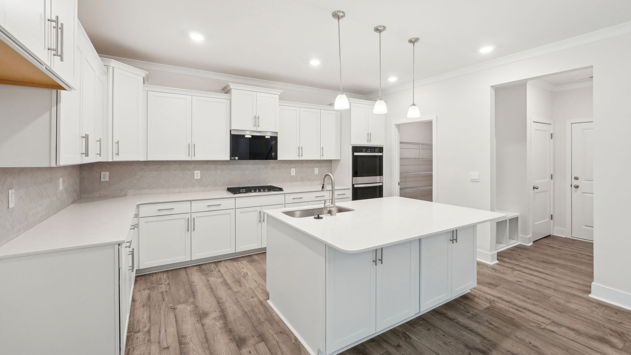 Kitchen and island with white cabinets and stainless steel appliances