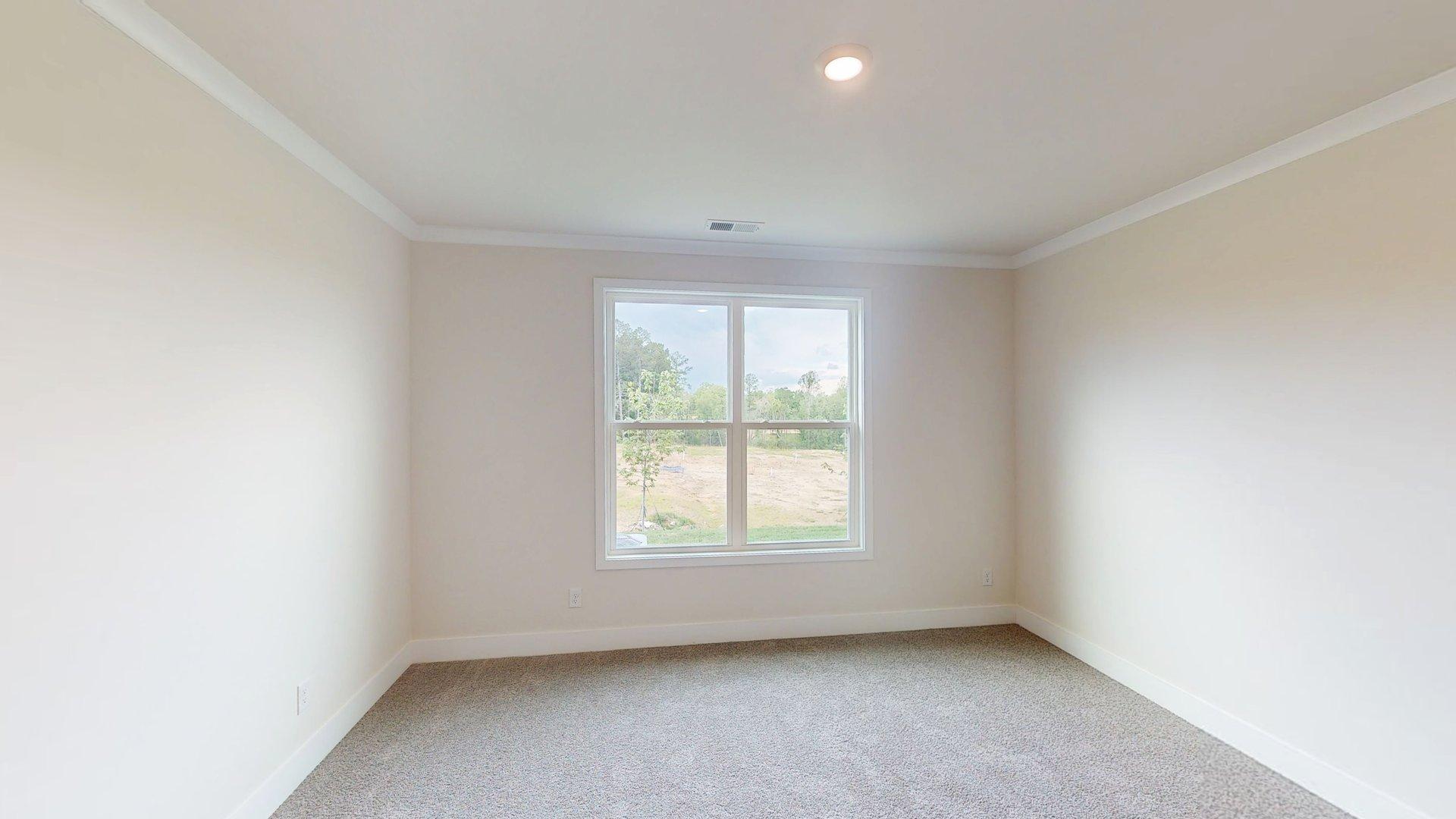 Carpeted bedroom with large windows