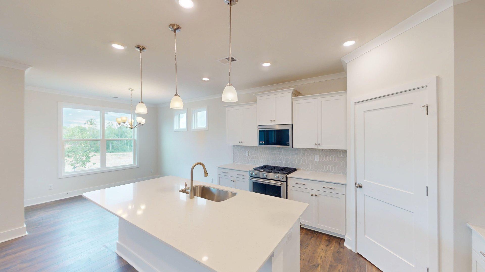 Kitchen and Island with white cabinets and stainless steel appliances