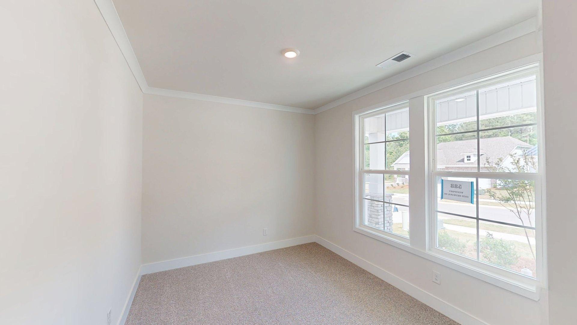 Carpeted bedroom with large windows