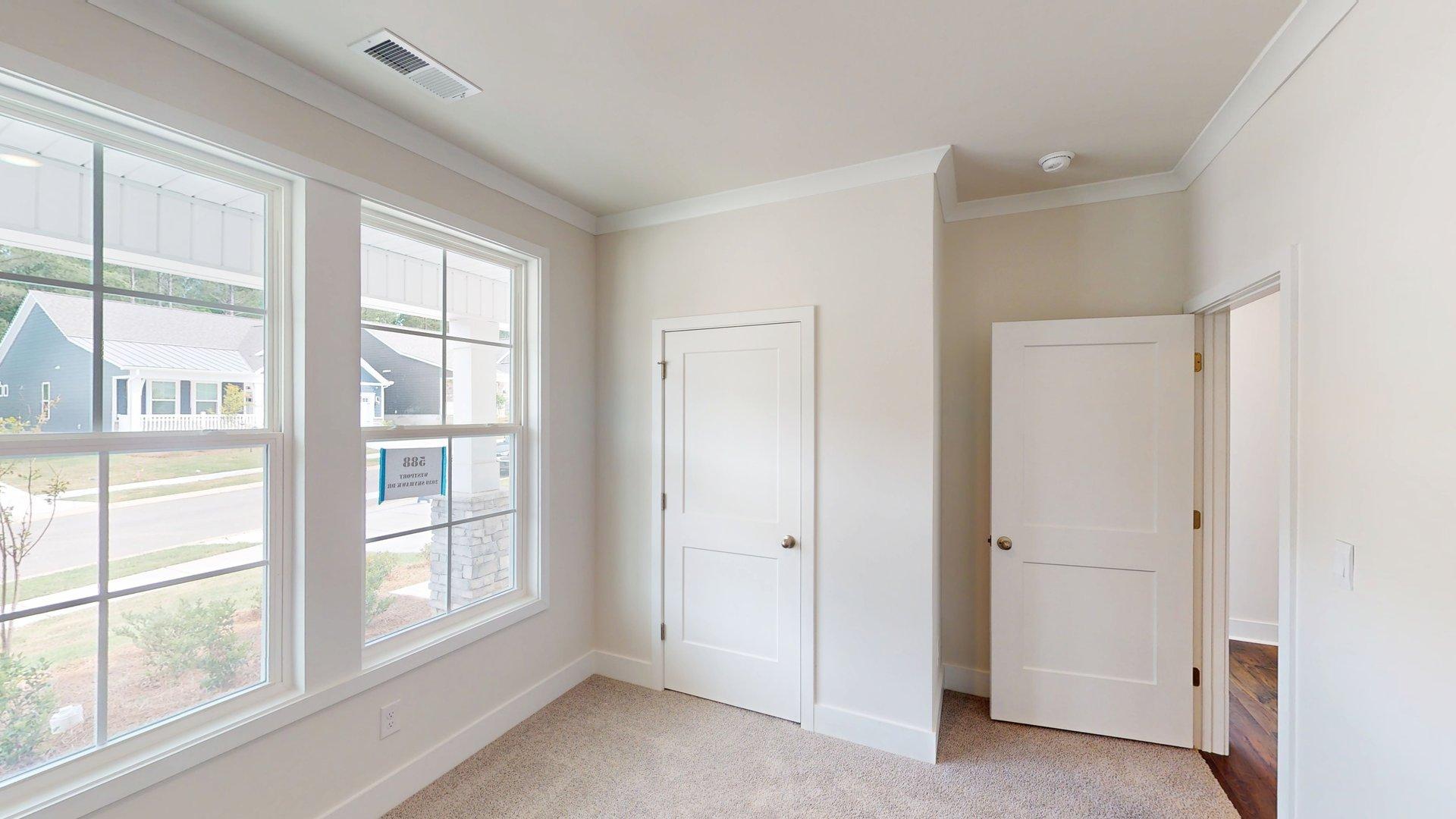 Carpeted bedroom with large windows