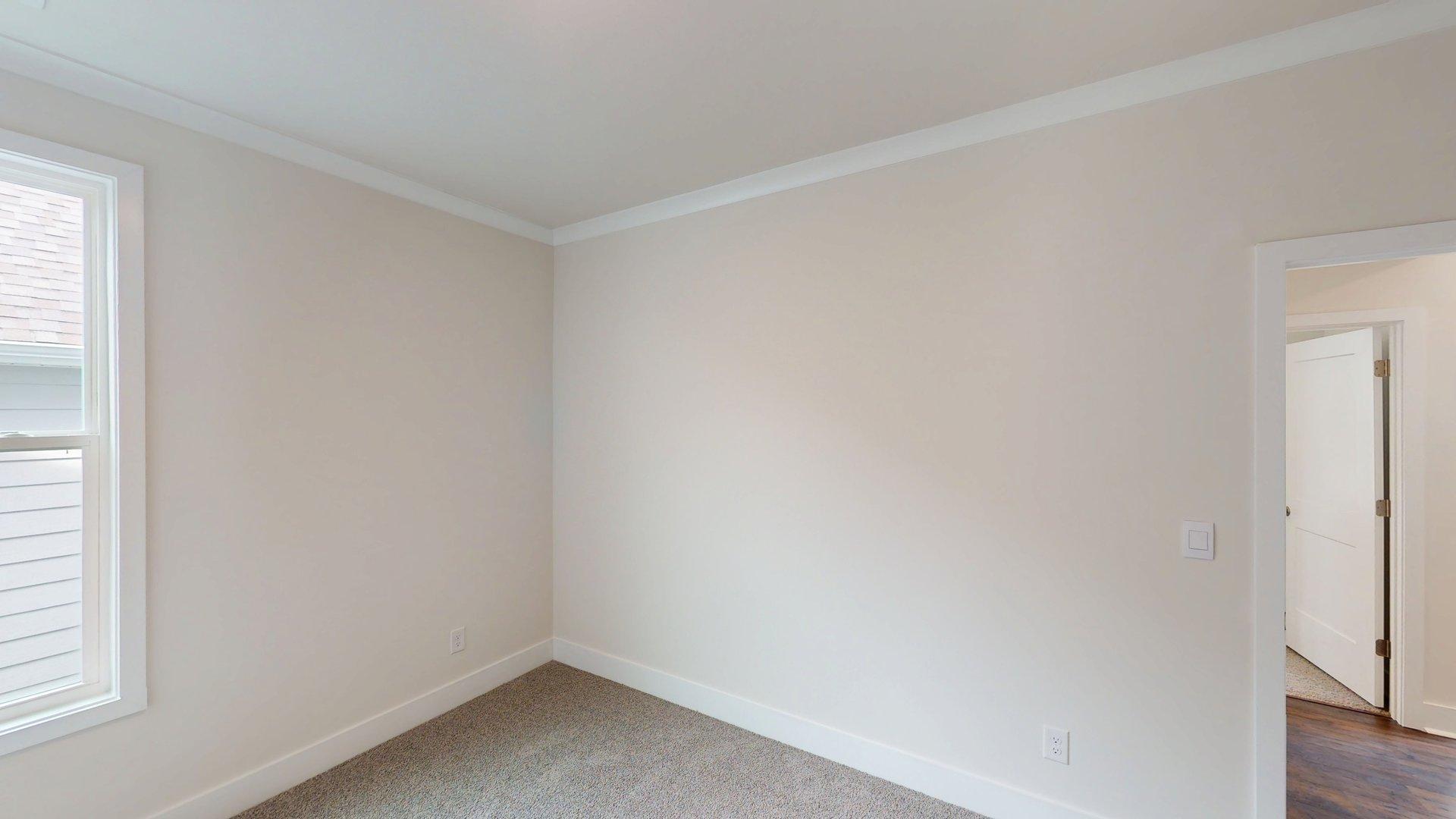 Carpeted bedroom with large windows