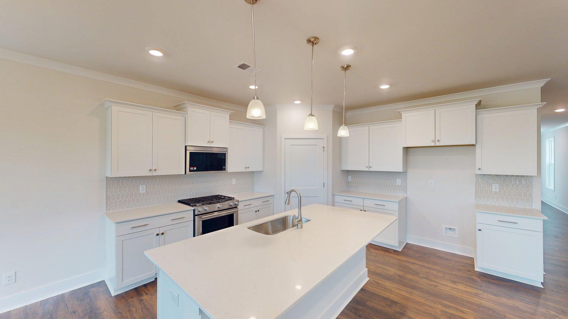 Kitchen and Island with white cabinets and stainless steel appliances