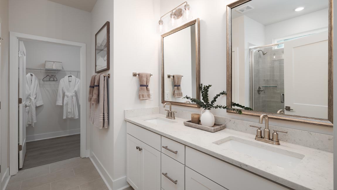 Primary bathroom white cabinets and large glass shower