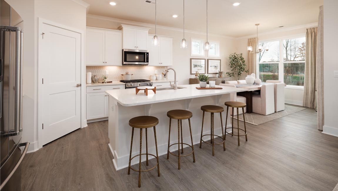 Kitchen and island with white cabinets and stainless steel appliances