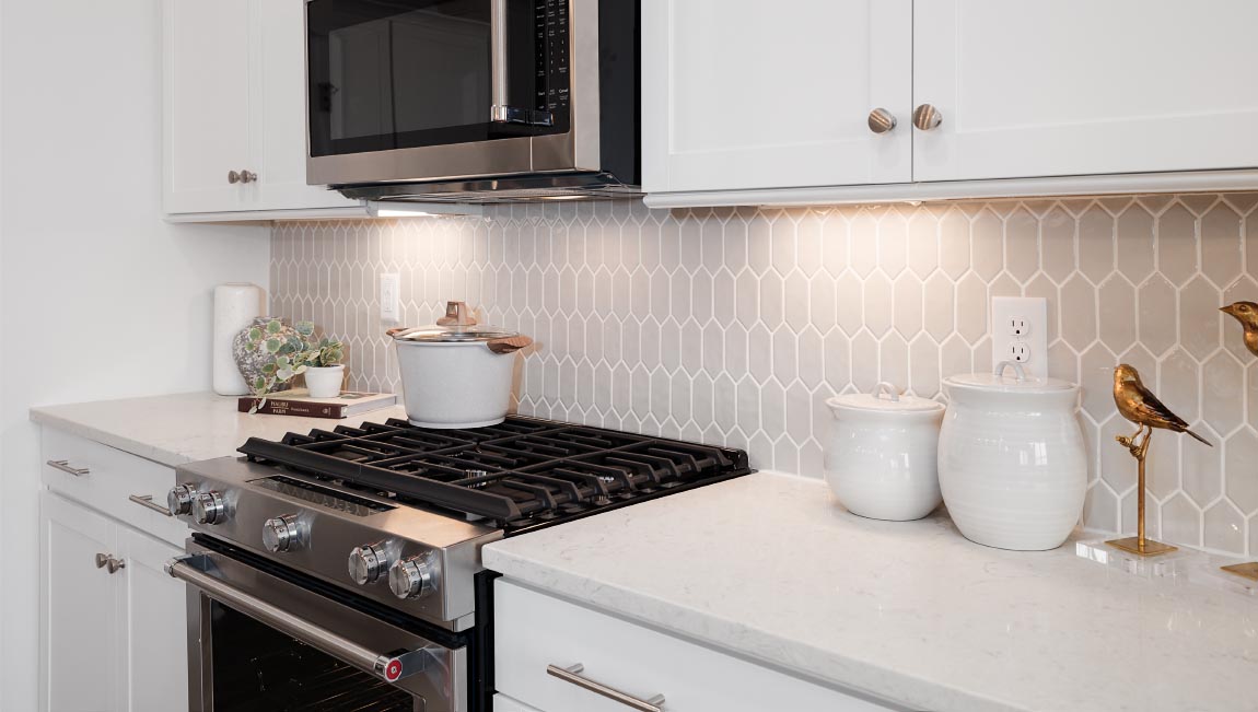 Kitchen and island with white cabinets and stainless steel appliances