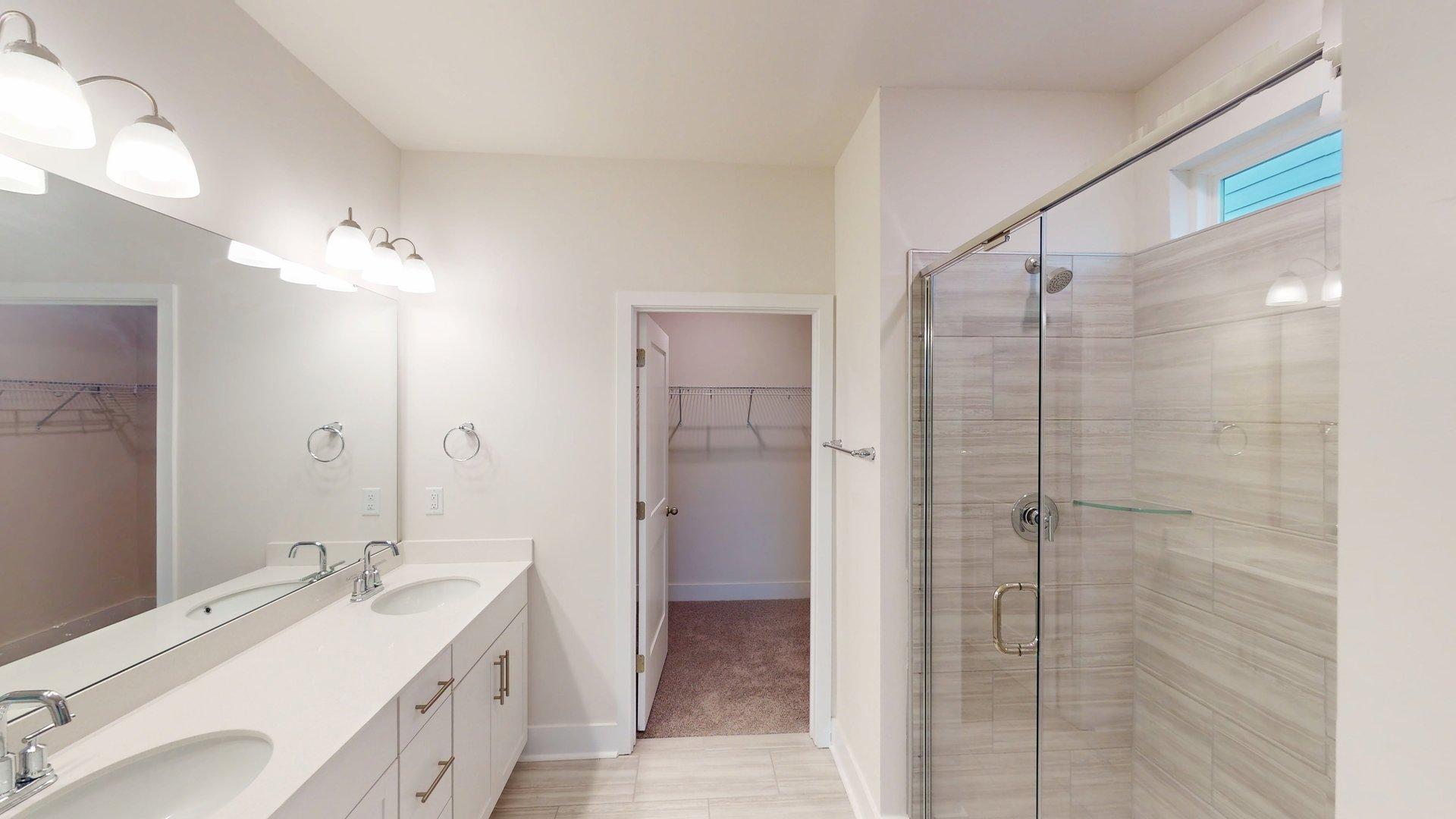 Bathroom with double sinks and standing glass shower