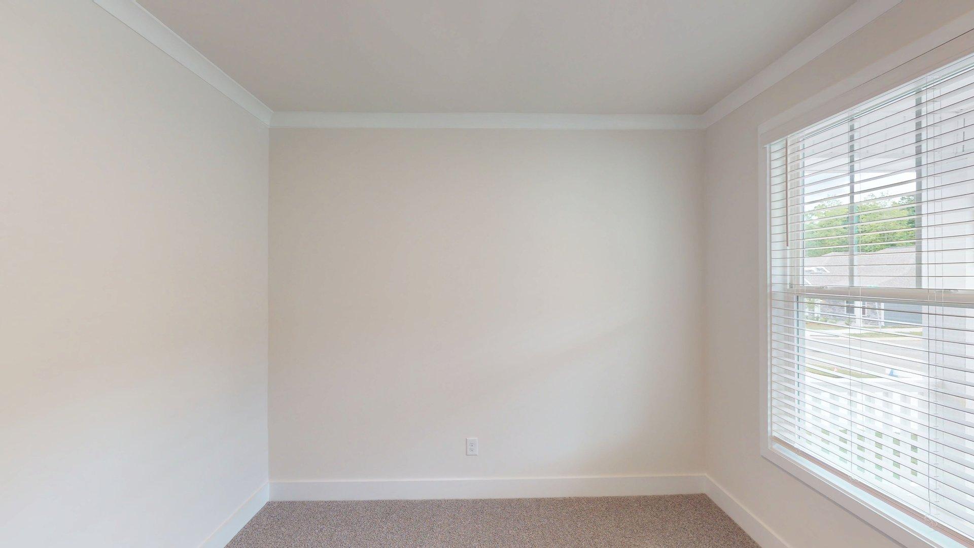 Carpeted bedroom with large window