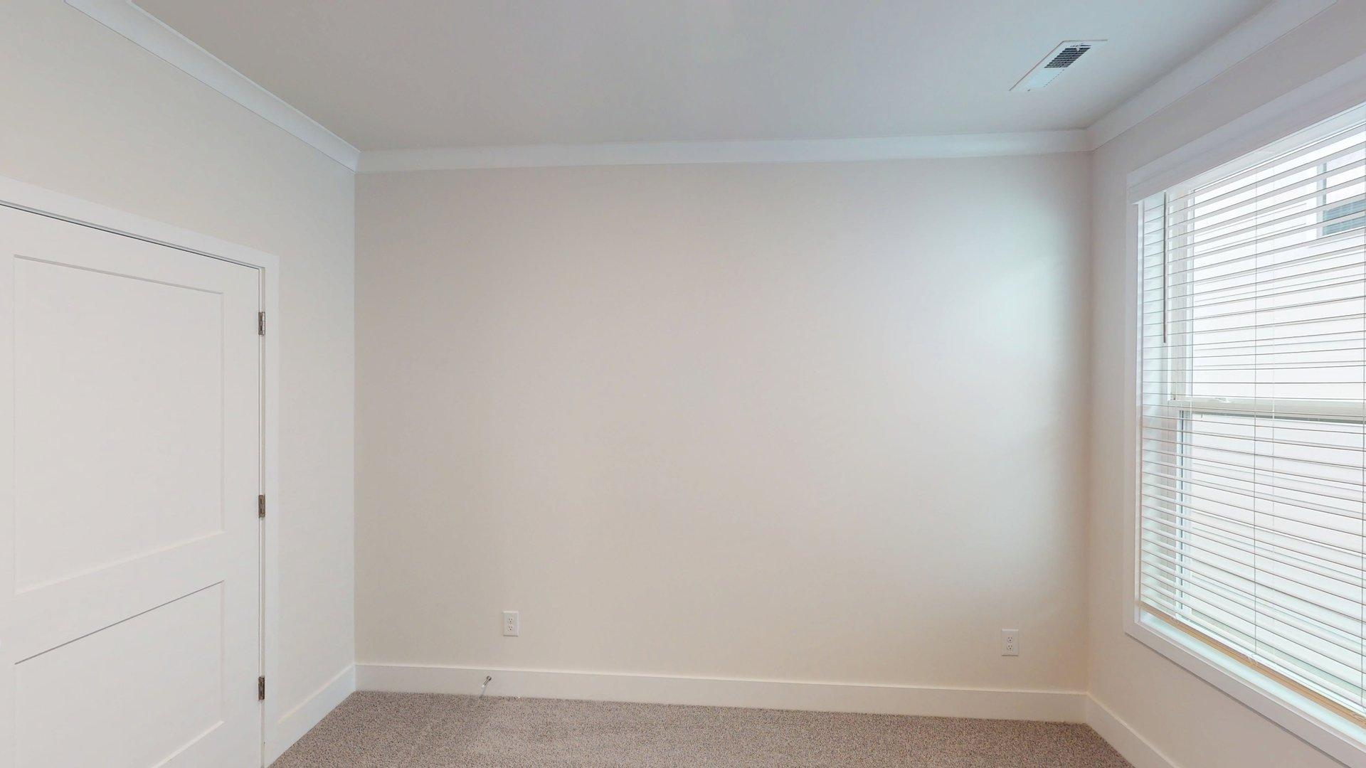 Carpeted bedroom with large window