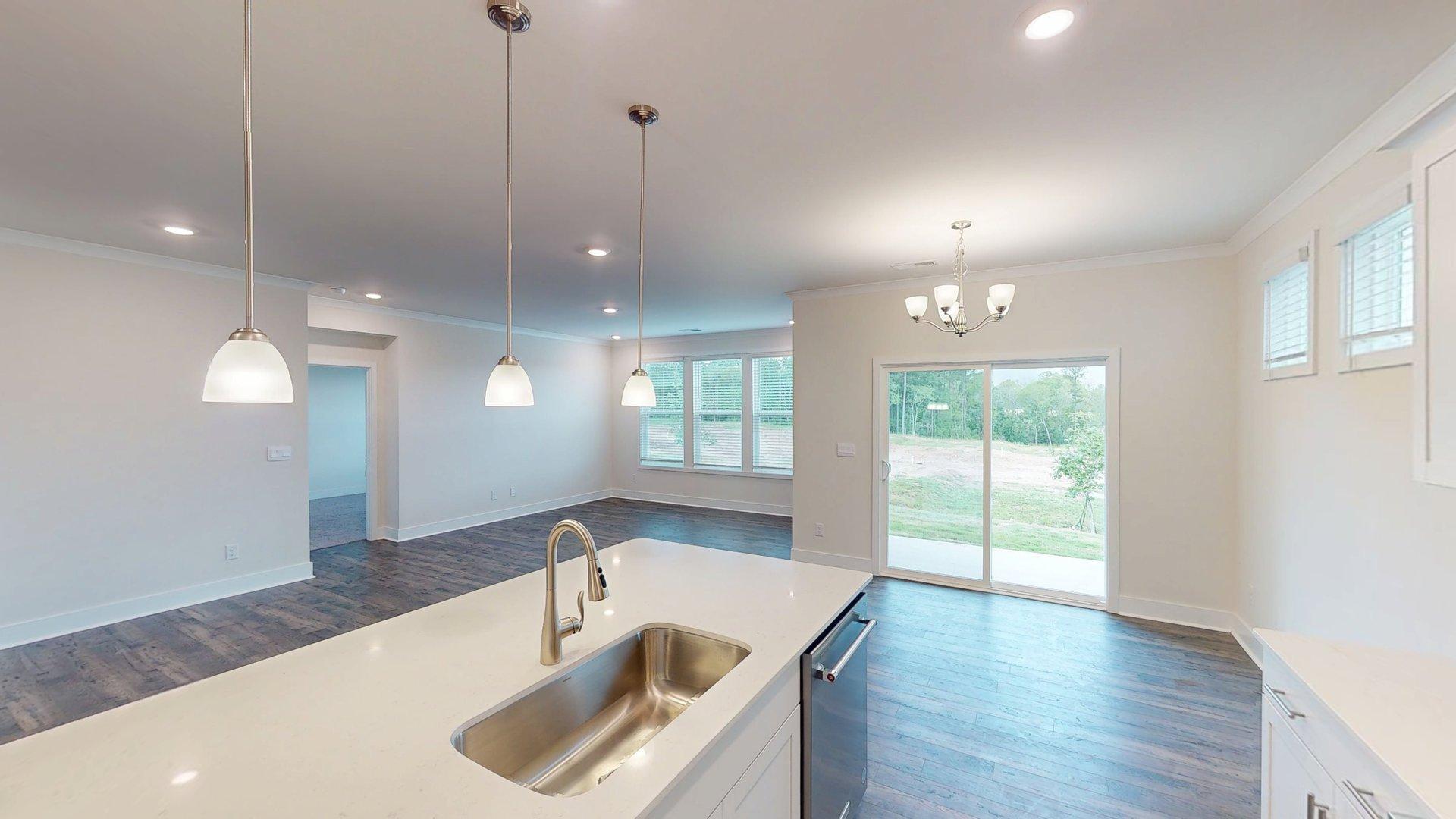 Kitchen and island with grey cabinets, white countertops, and stainless steel appliances