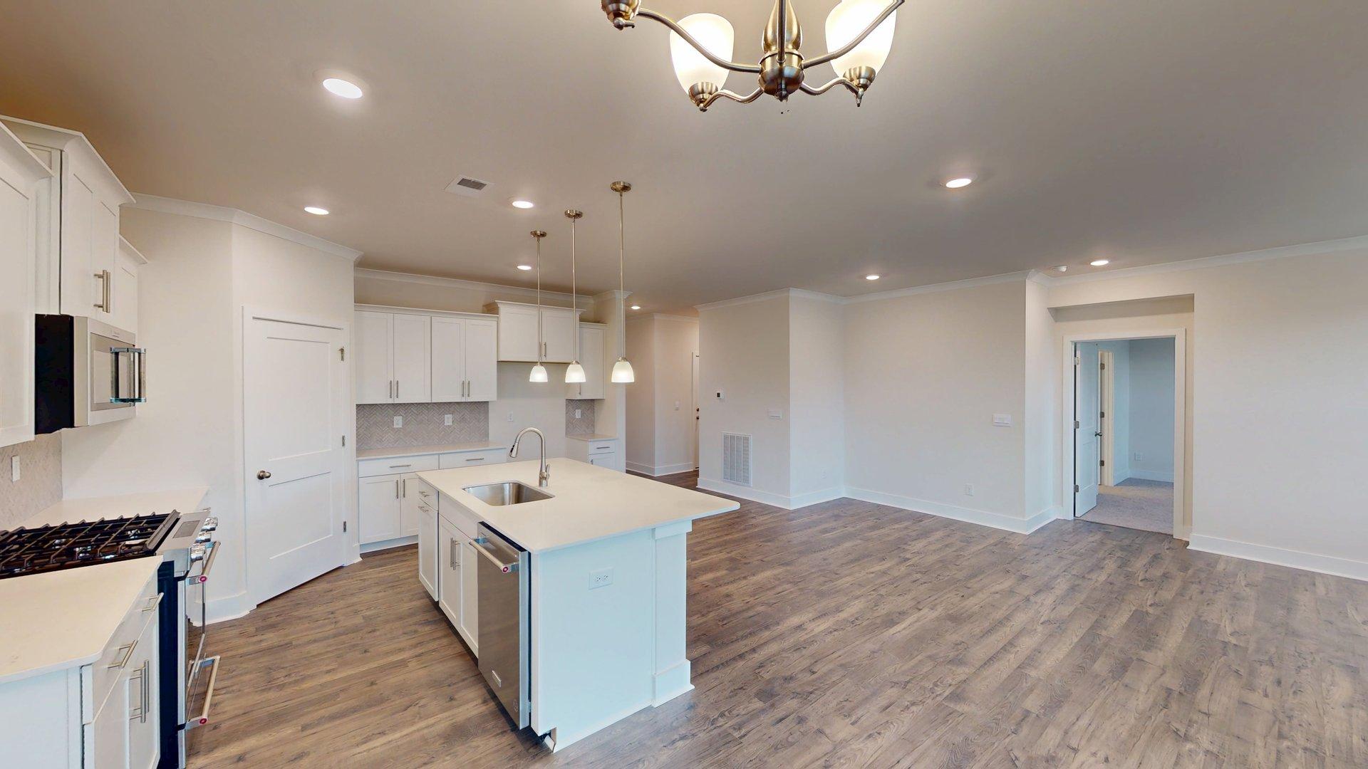 Kitchen and island with grey cabinets, white countertops, and stainless steel appliances