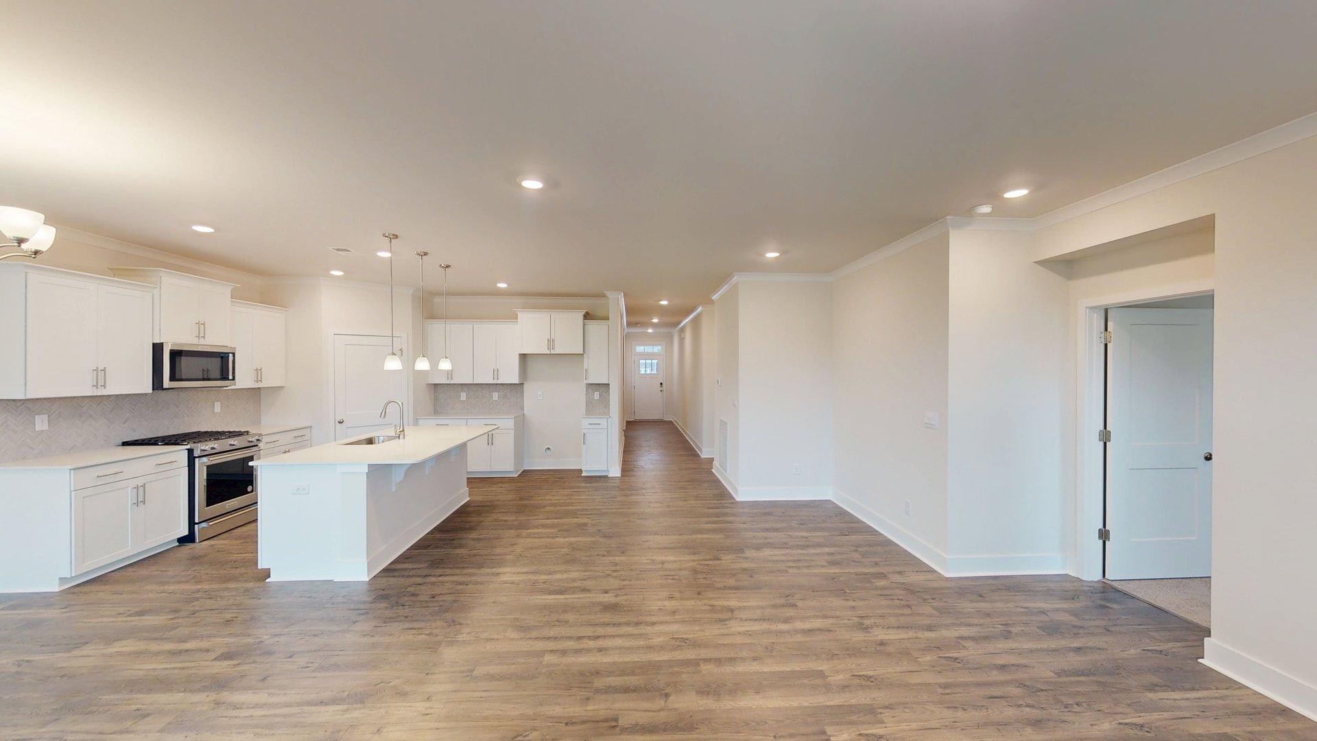 Living room with three large windows, beside dining area