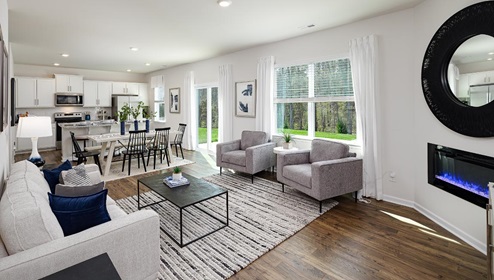 Fergus Crossing Penwell Model living room with wood floors, electric fireplace and large window