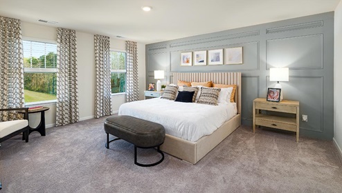Fergus Crossing Penwell Model primary bedroom with carpet and two large windows