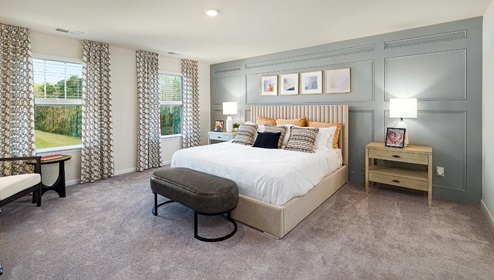 Fergus Crossing Penwell Model  primary bedroom with carpet and two large windows