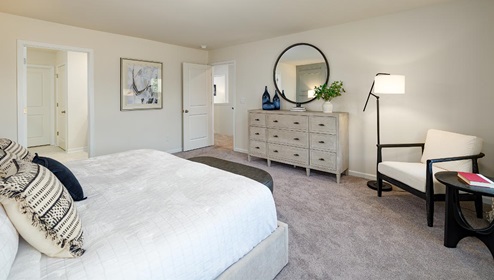 Fergus Crossing Penwell Model primary bedroom with carpet and two large windows