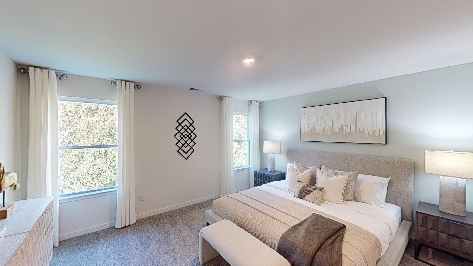 Primary carpeted bedroom with large window