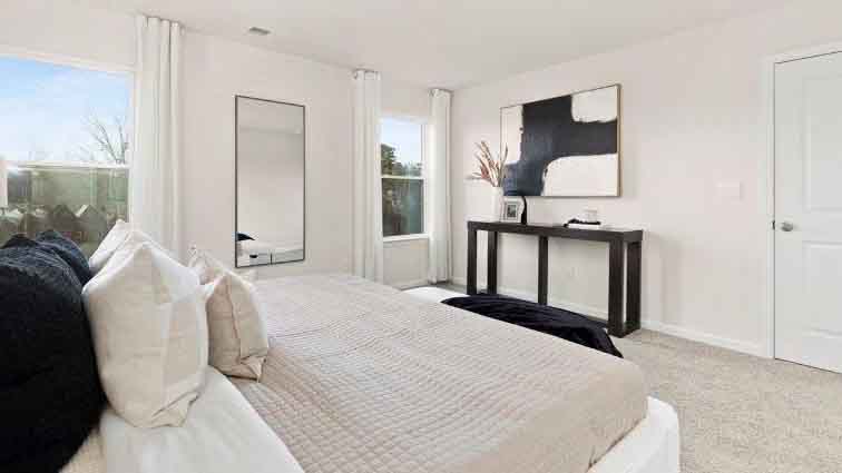 Primary carpeted bedroom with large window