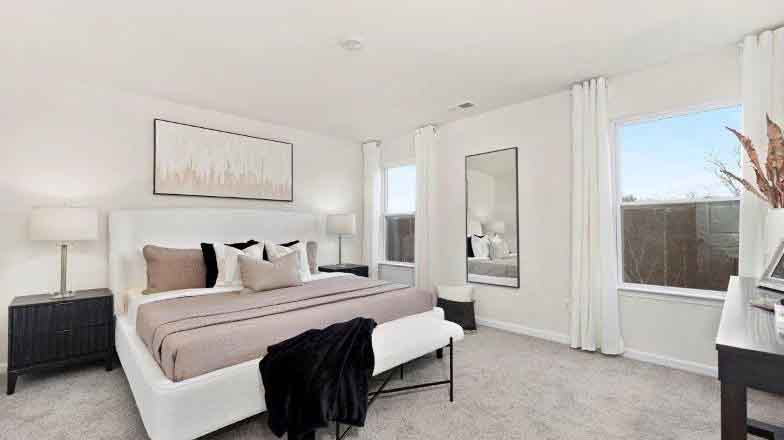 Primary carpeted bedroom with large window