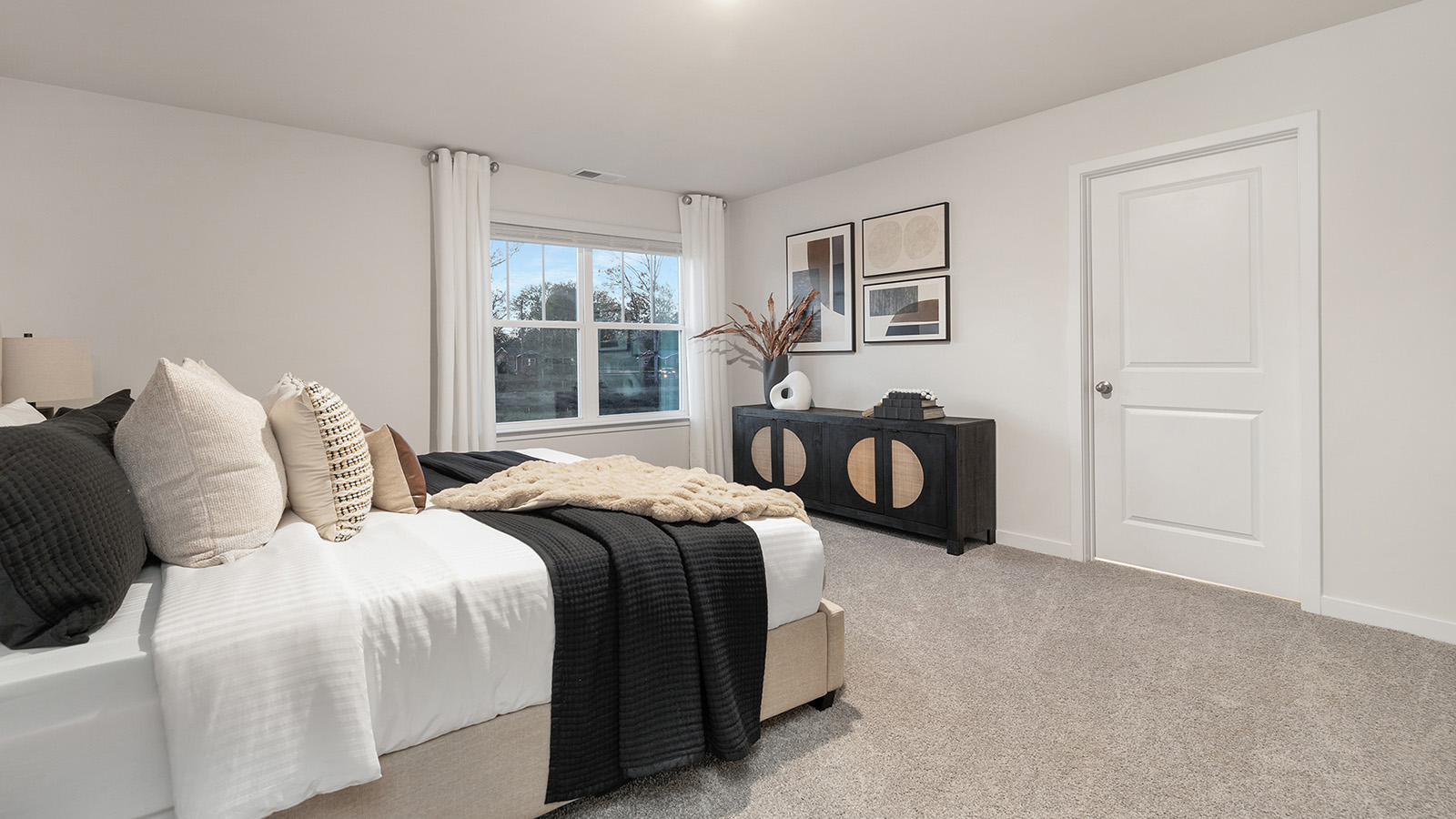 Primary carpeted bedroom with large window