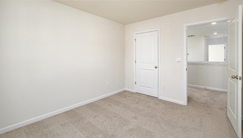 Carpeted bedroom view of entryway