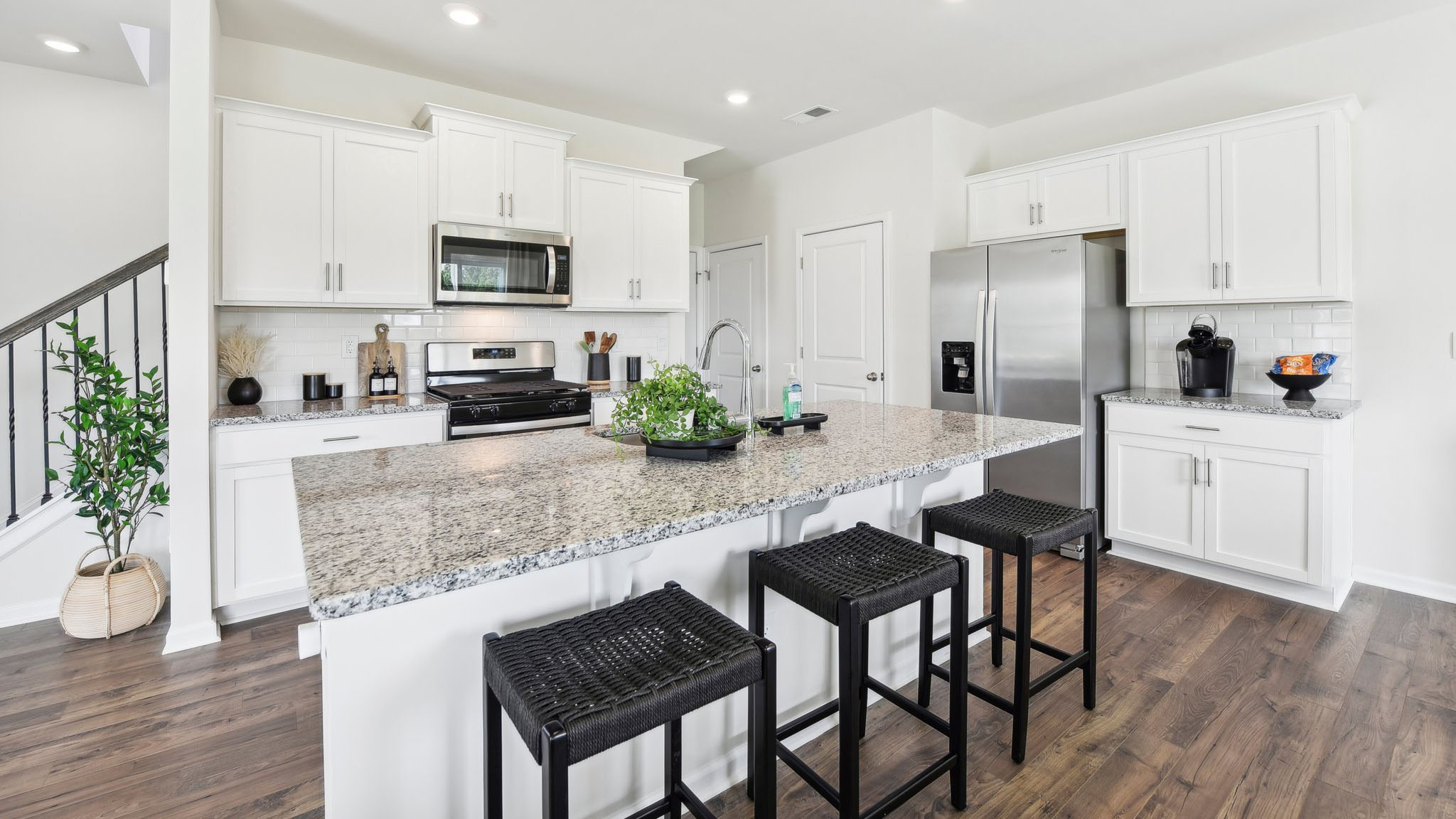 Kitchen and island, white cabinets, wood floors