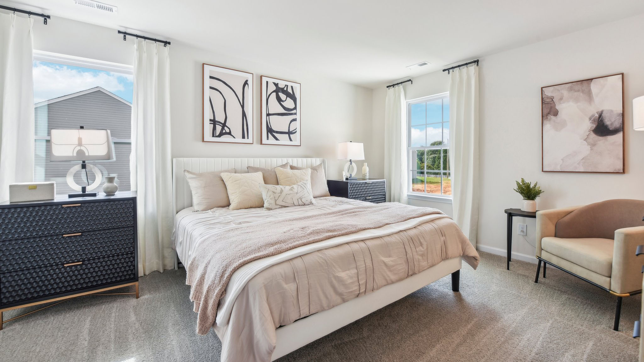 Primary carpeted bedroom with windows