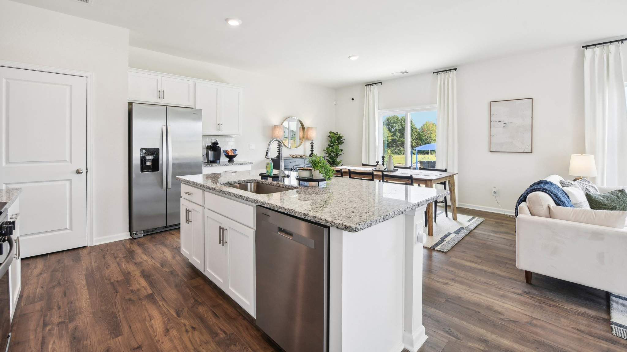 Kitchen and island, white cabinets, wood floors
