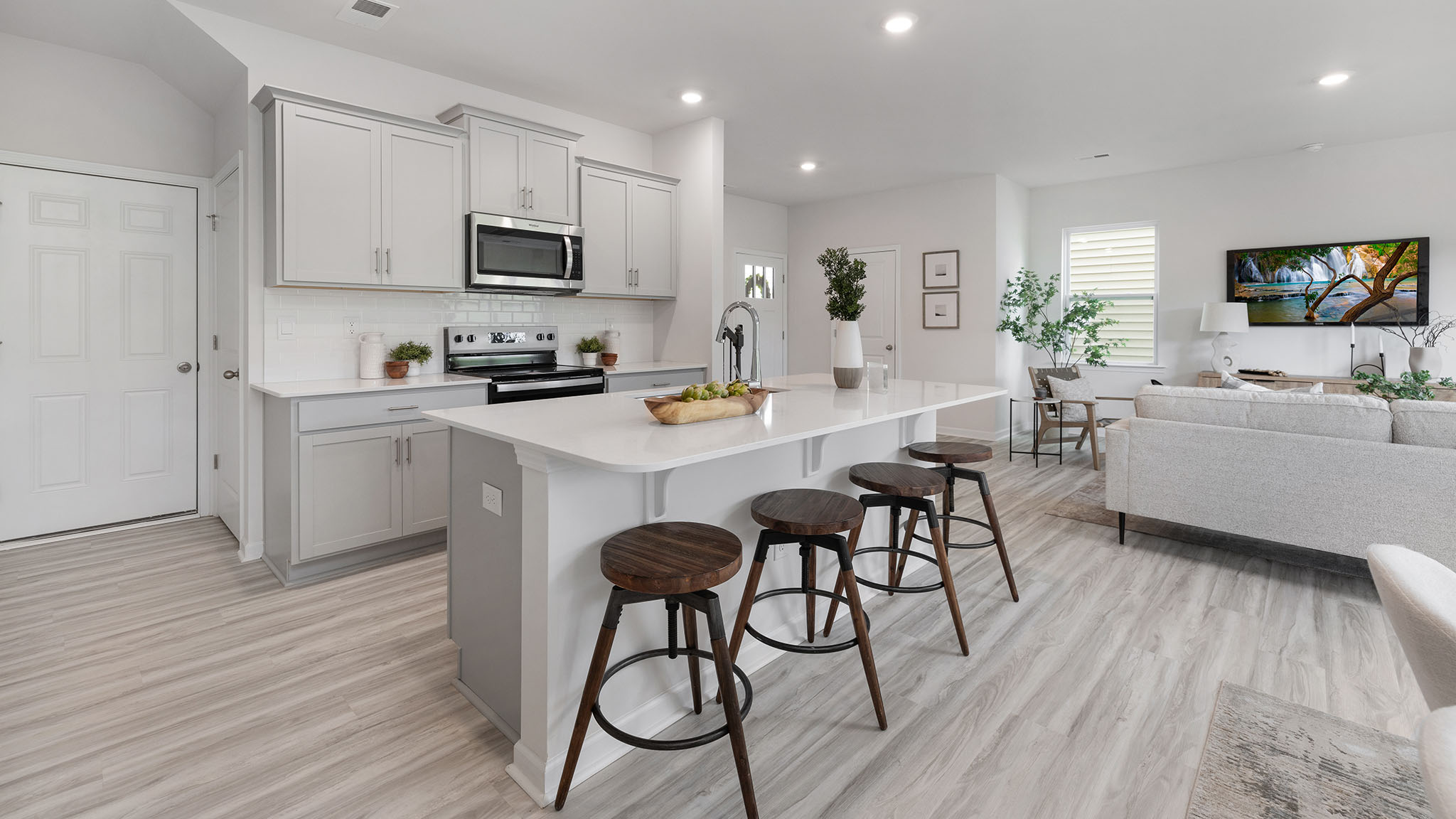 Kitchen and island, white cabinets, wood floors