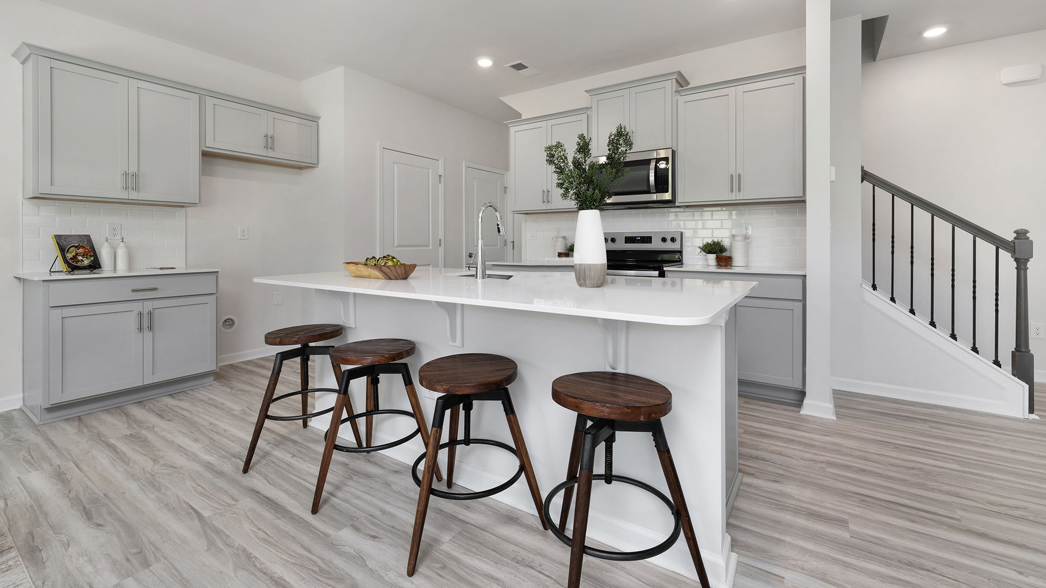 Kitchen and island, white cabinets, wood floors