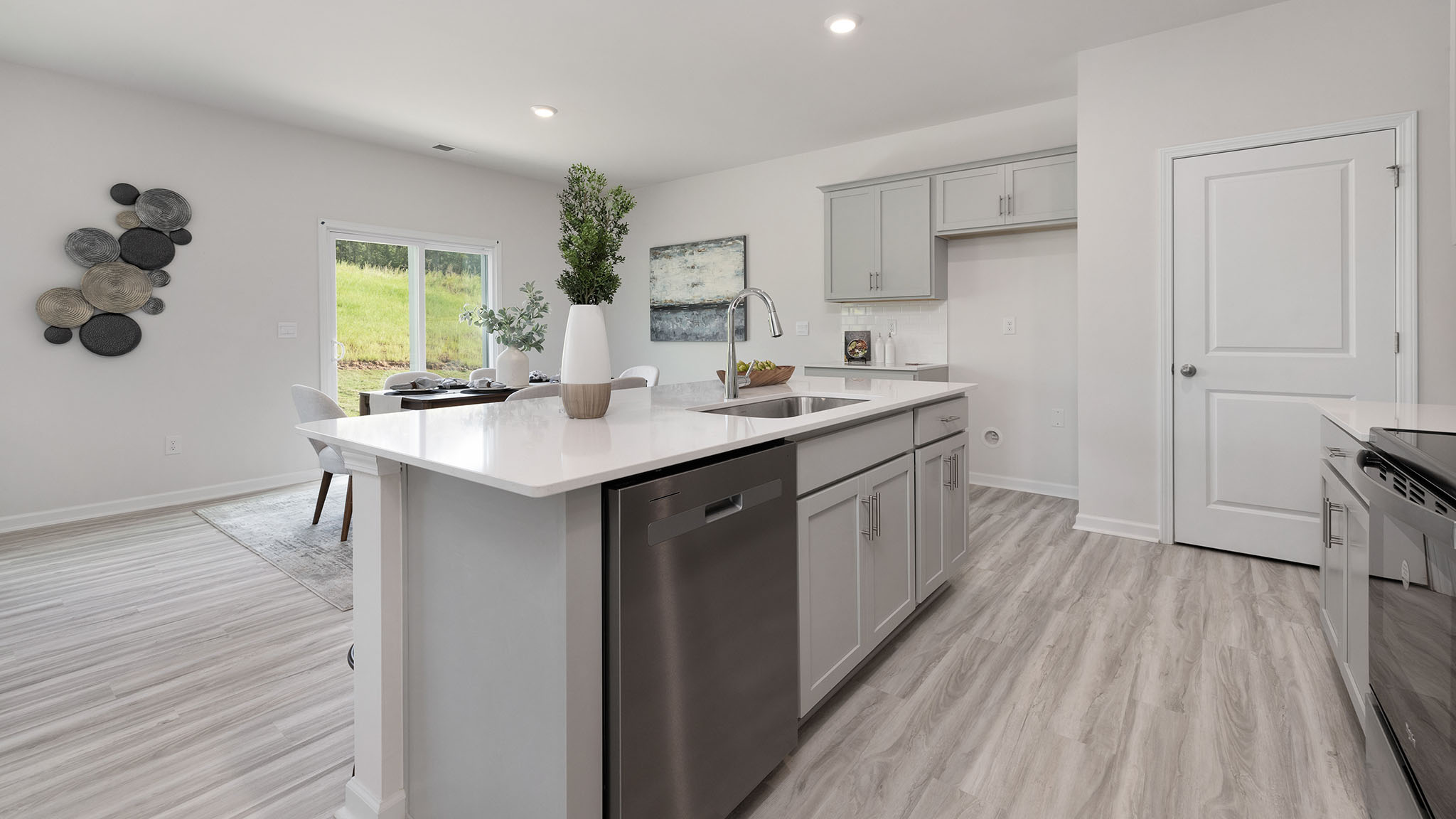 Kitchen and island, white cabinets, wood floors