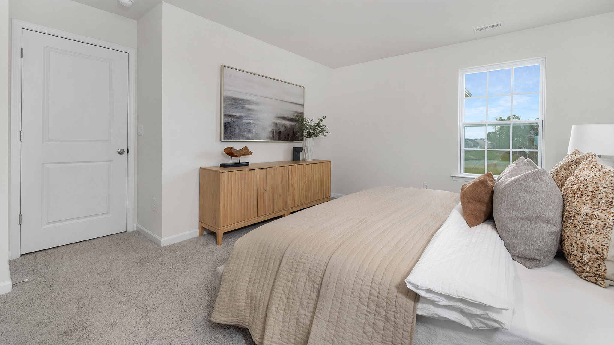 Primary carpeted bedroom with windows
