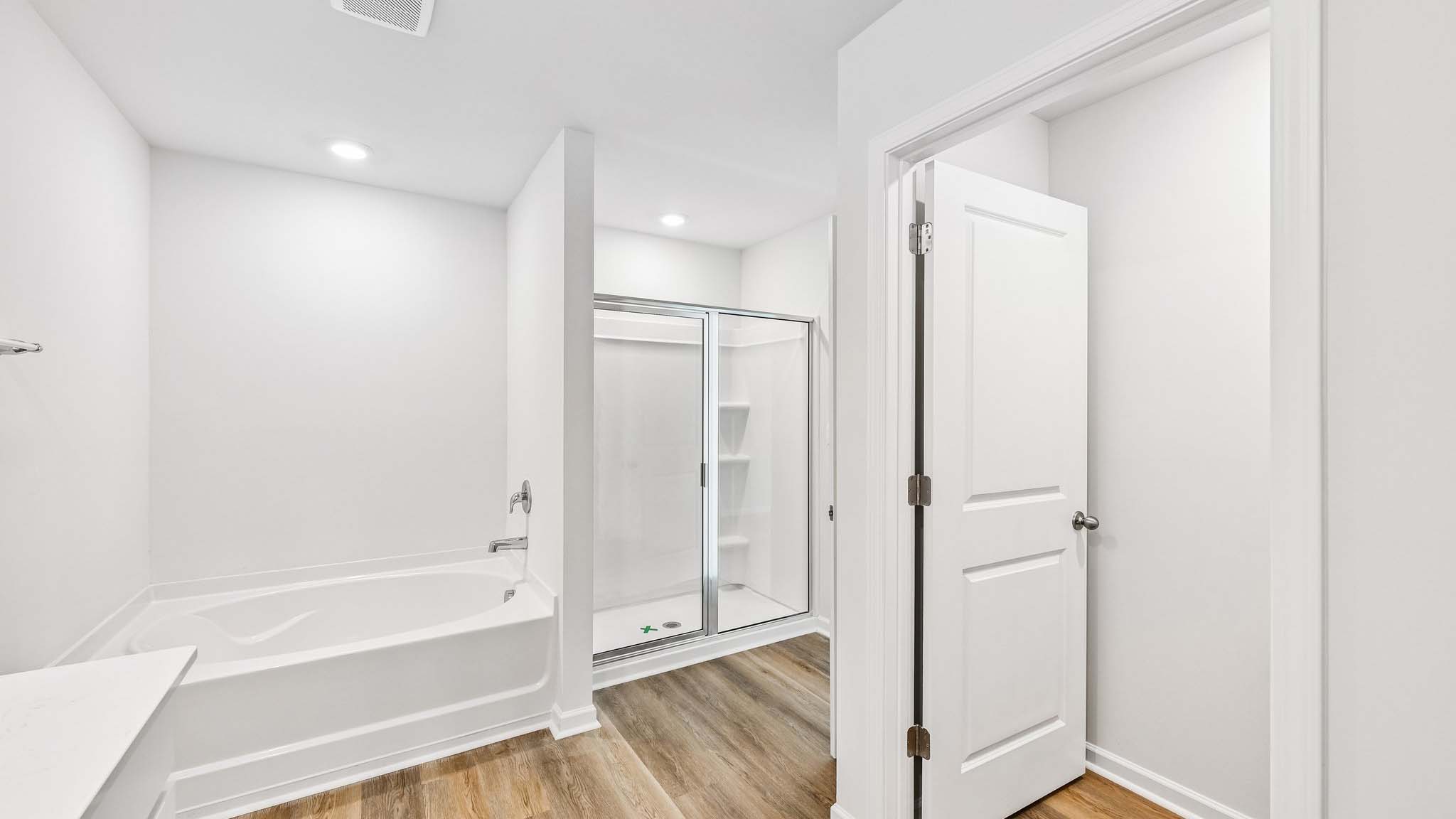 primary bathroom with dual vanity and walk in shower and soaking tub