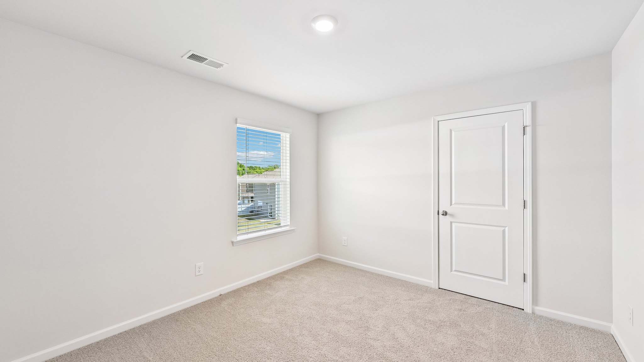 carpeted bedroom with large window