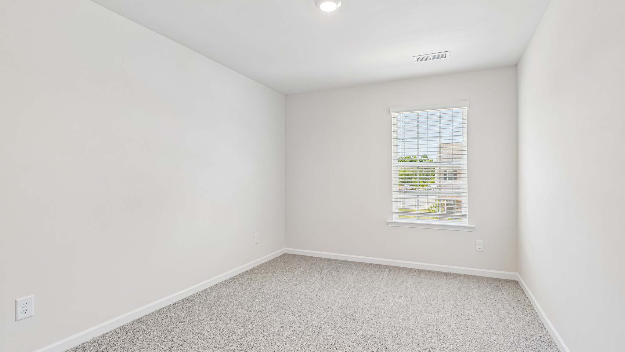 carpeted bedroom with large window