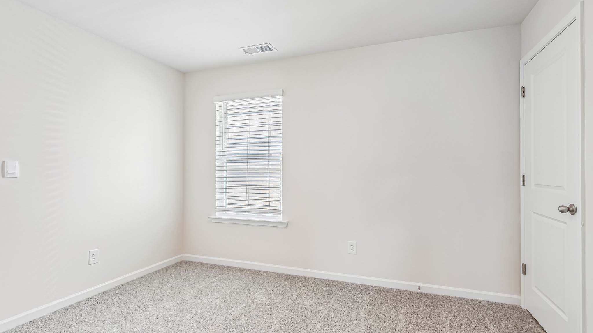 carpeted bedroom with large window
