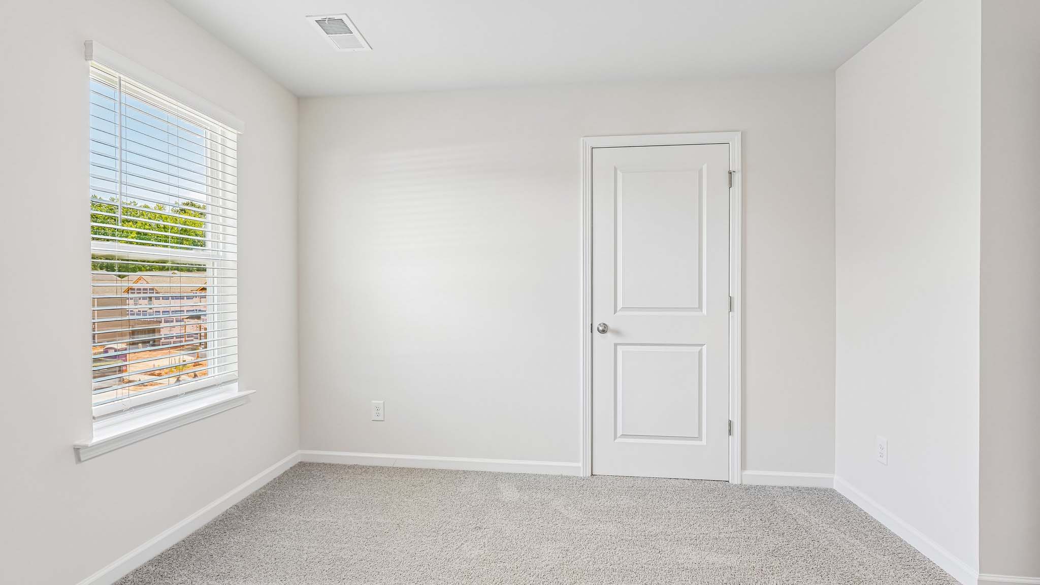 carpeted bedroom with large window