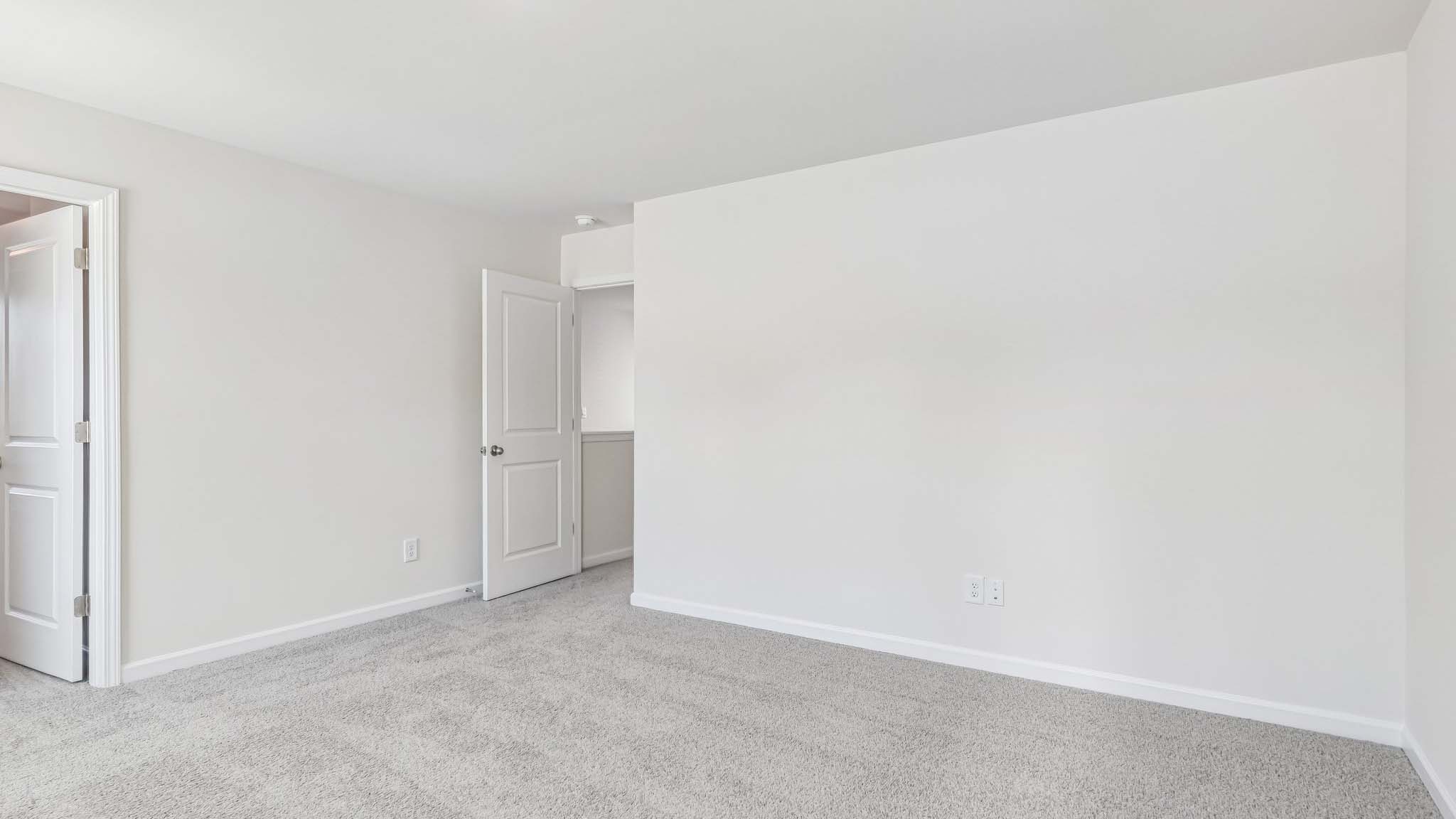 primary carpeted bedroom with windows