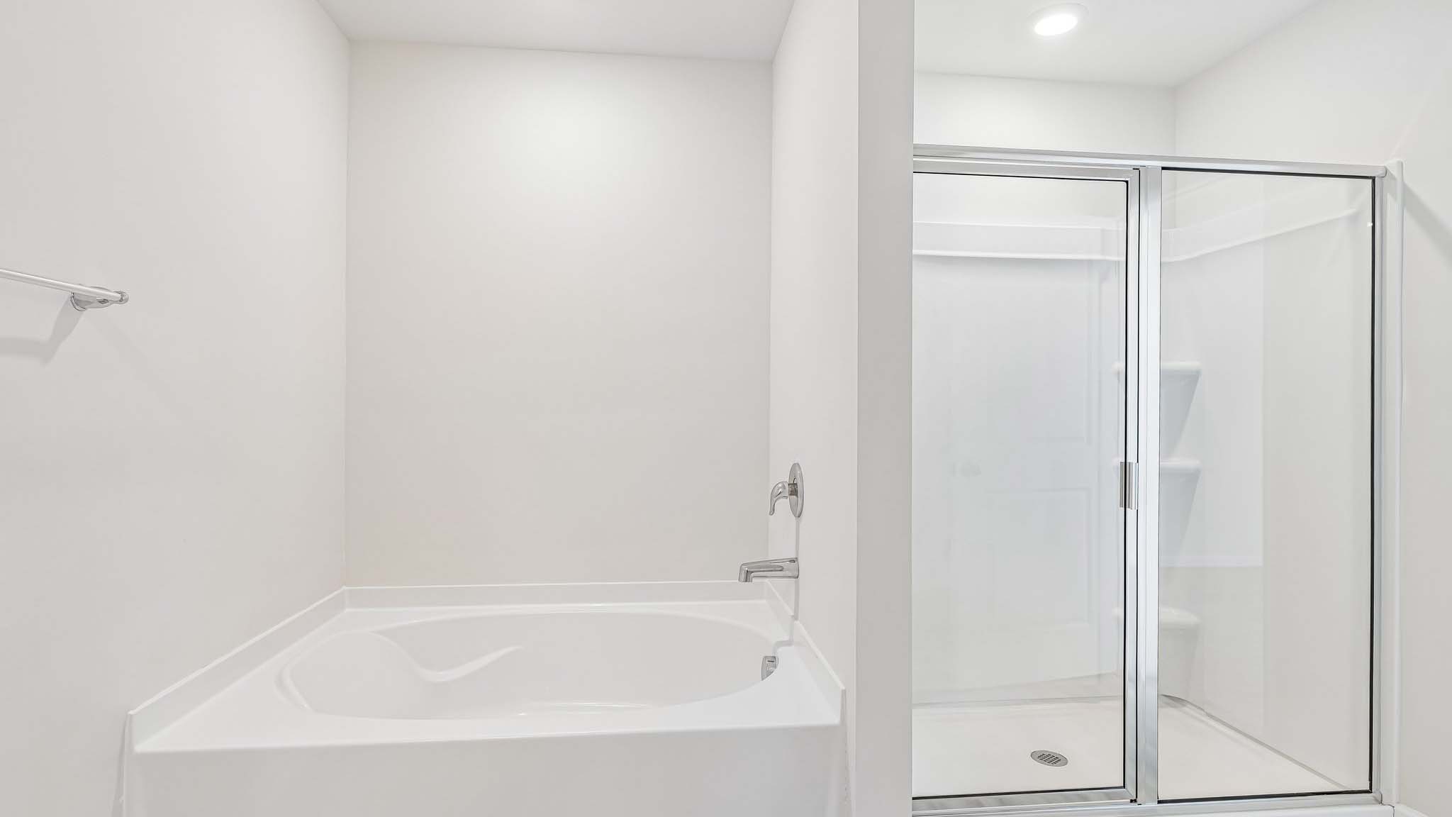 primary bathroom with dual vanity and walk in shower and soaking tub