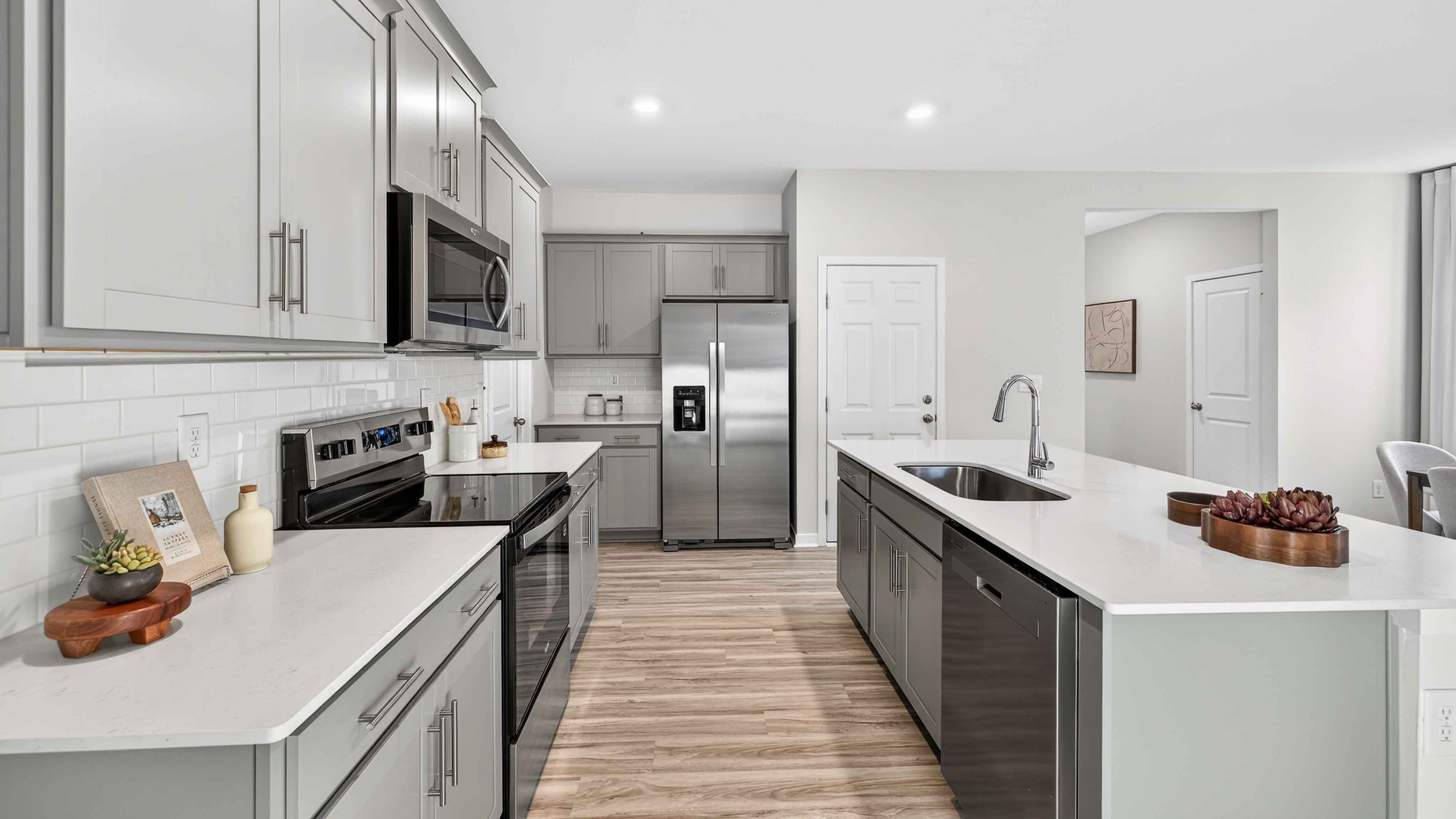 Kitchen and island with white cabinets, subway tile backsplash, and stainless steel appliances
