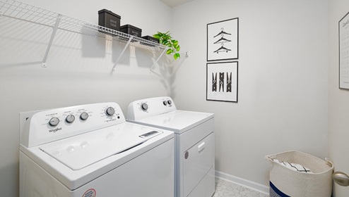 Laundry room with built in hanger and storage racks above machines