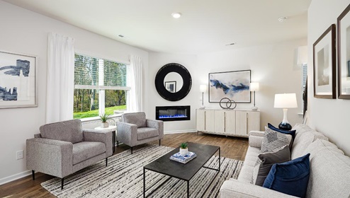 Fergus Crossing Penwell Model living room with wood floors, electric fireplace and large window