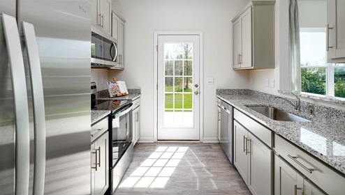 Fergus Crossing Townhomes Newton Model kitchen with white cabinets, and stainless steel appliances