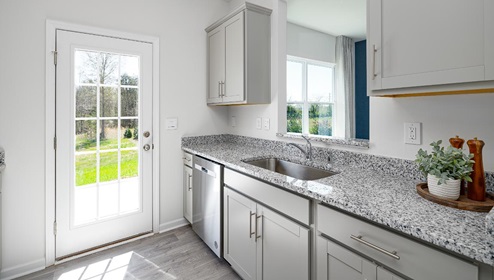 Fergus Crossing Townhomes Newton Model kitchen with white cabinets, and stainless steel appliances